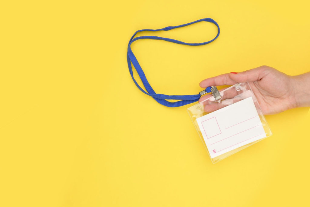 hand holding name tag against yellow background