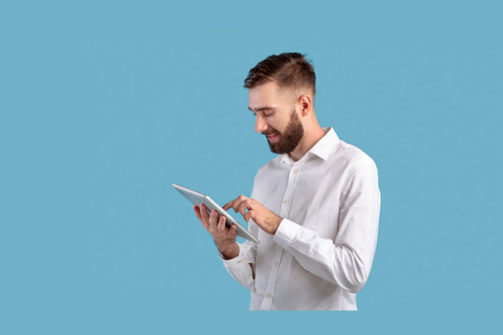 Professional using a tablet against a blue background, representing sales enablement and training through digital tools and learning resources