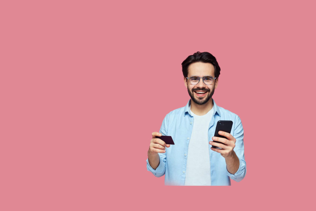 Smiling professional holding a credit card and smartphone, representing tracking performance and outcomes with a sales enablement scorecard