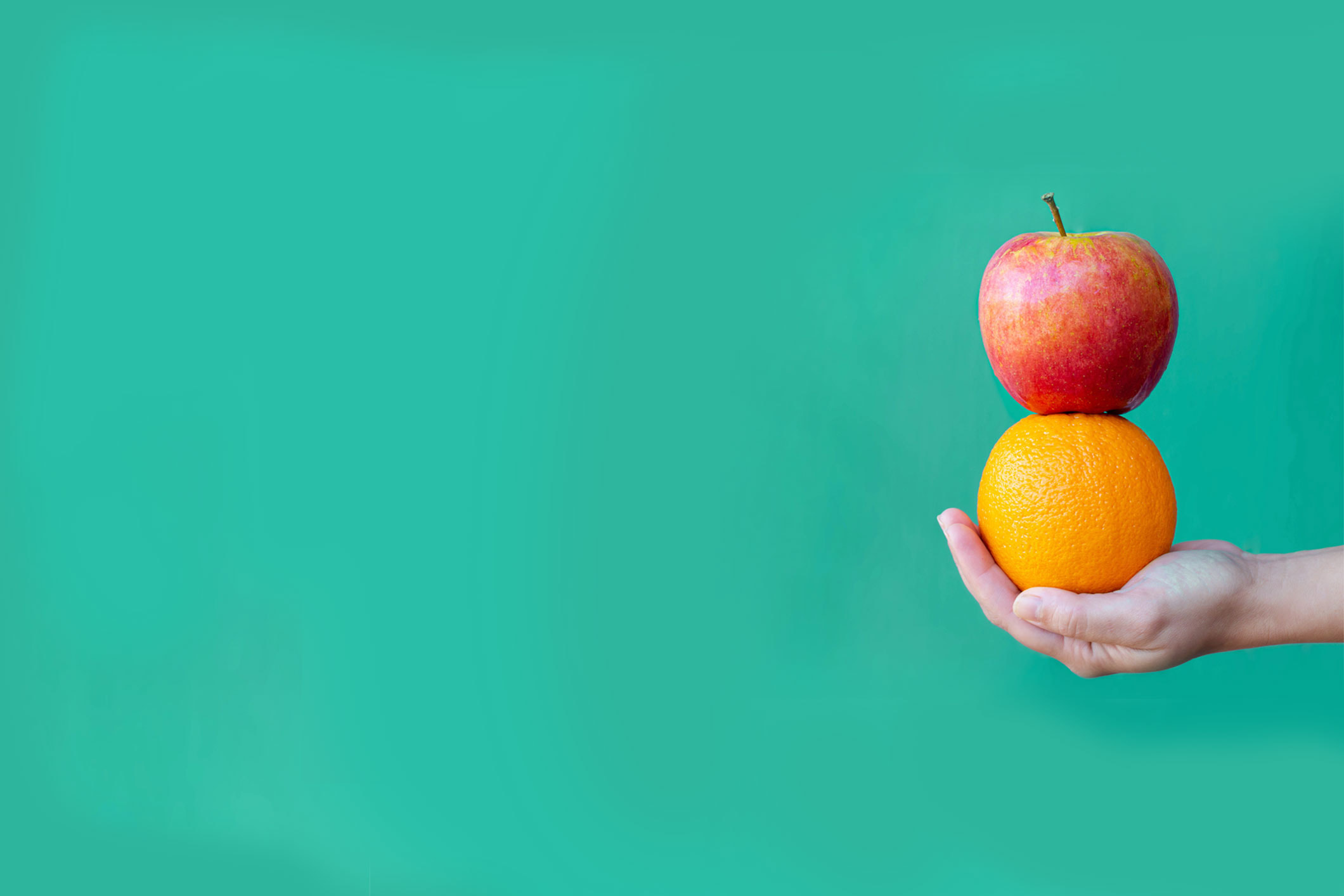 assumptions in marketing hand holding orange and apple