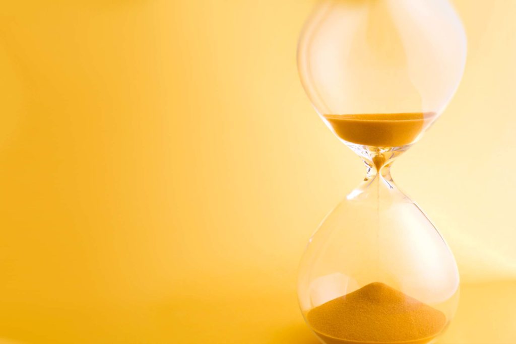 hourglass with yellow sand and background