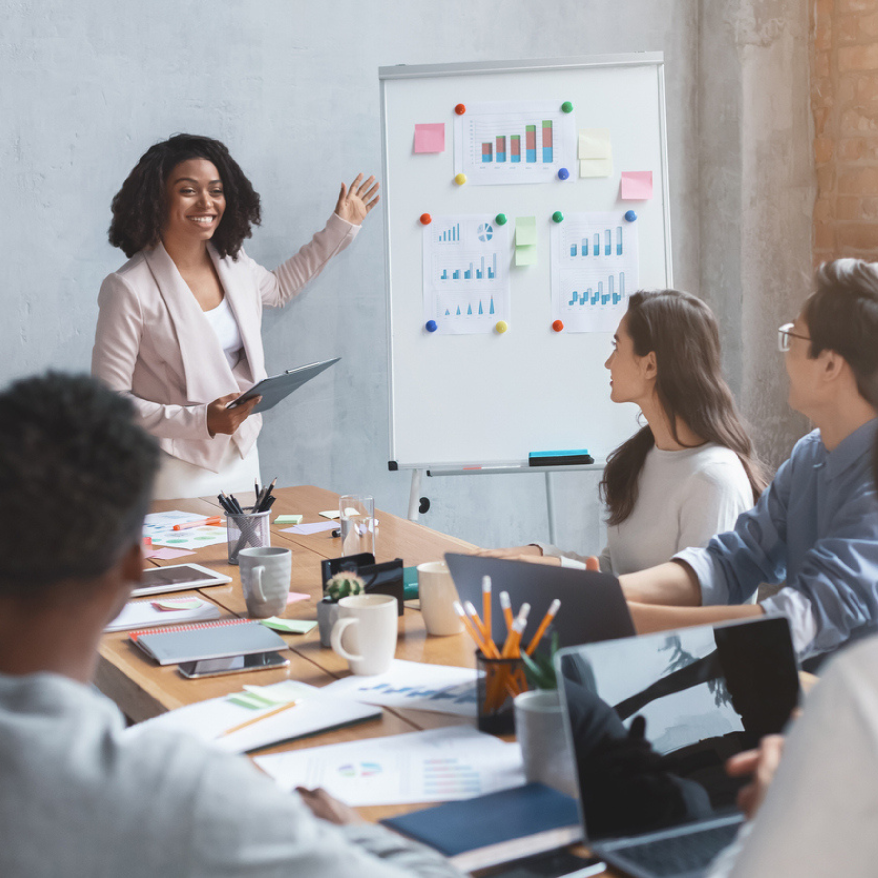 A marketing leader presenting data and charts to a collaborative team, illustrating Aventi Group’s expertise in strategic product marketing.