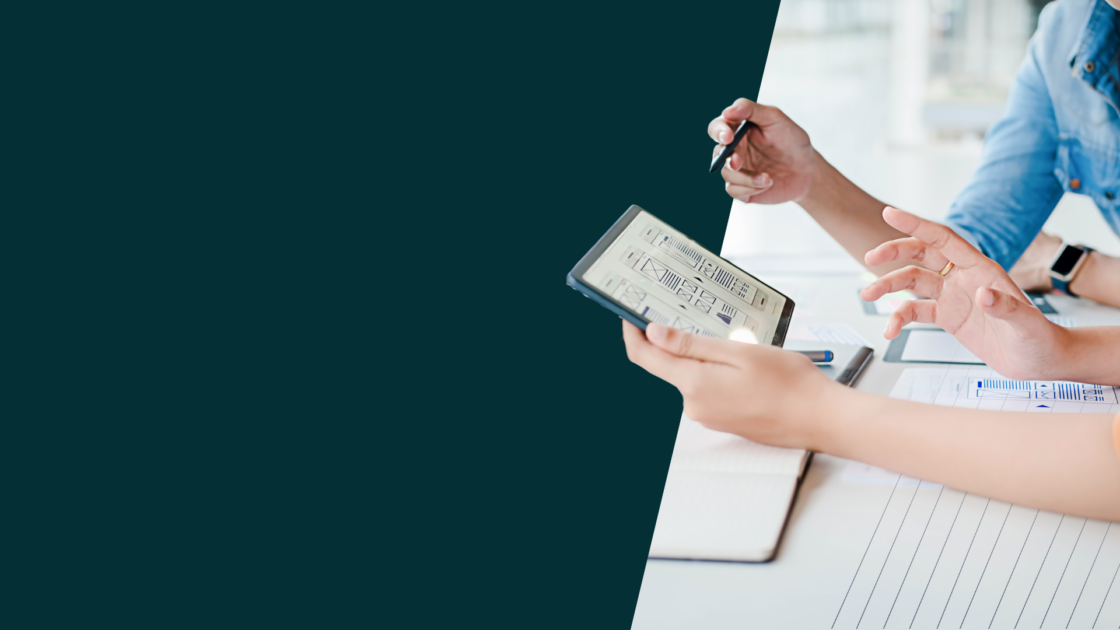 Professionals reviewing website wireframes on a tablet, representing strong SEO Fundamentals and structured content strategy in the age of AI.